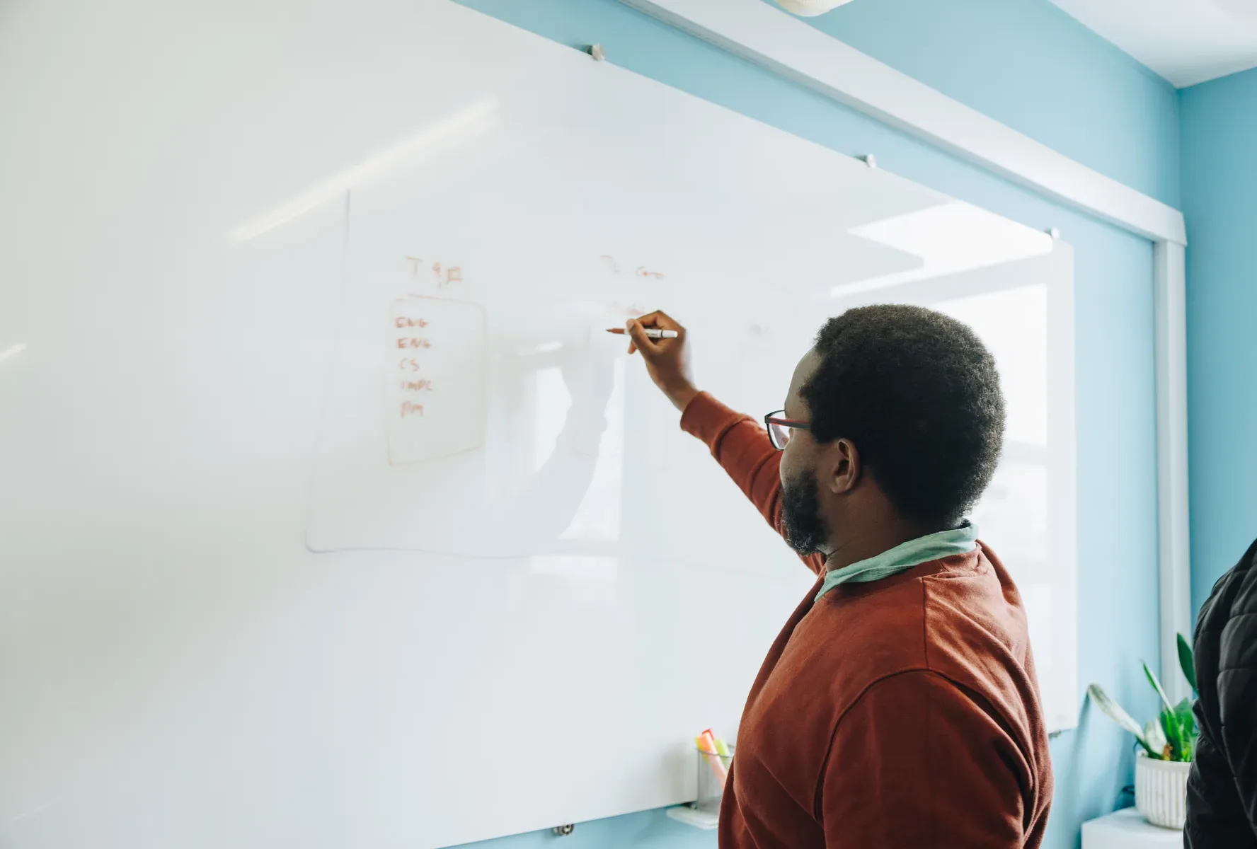 A member of the Jem team writing on a whiteboard in the office.