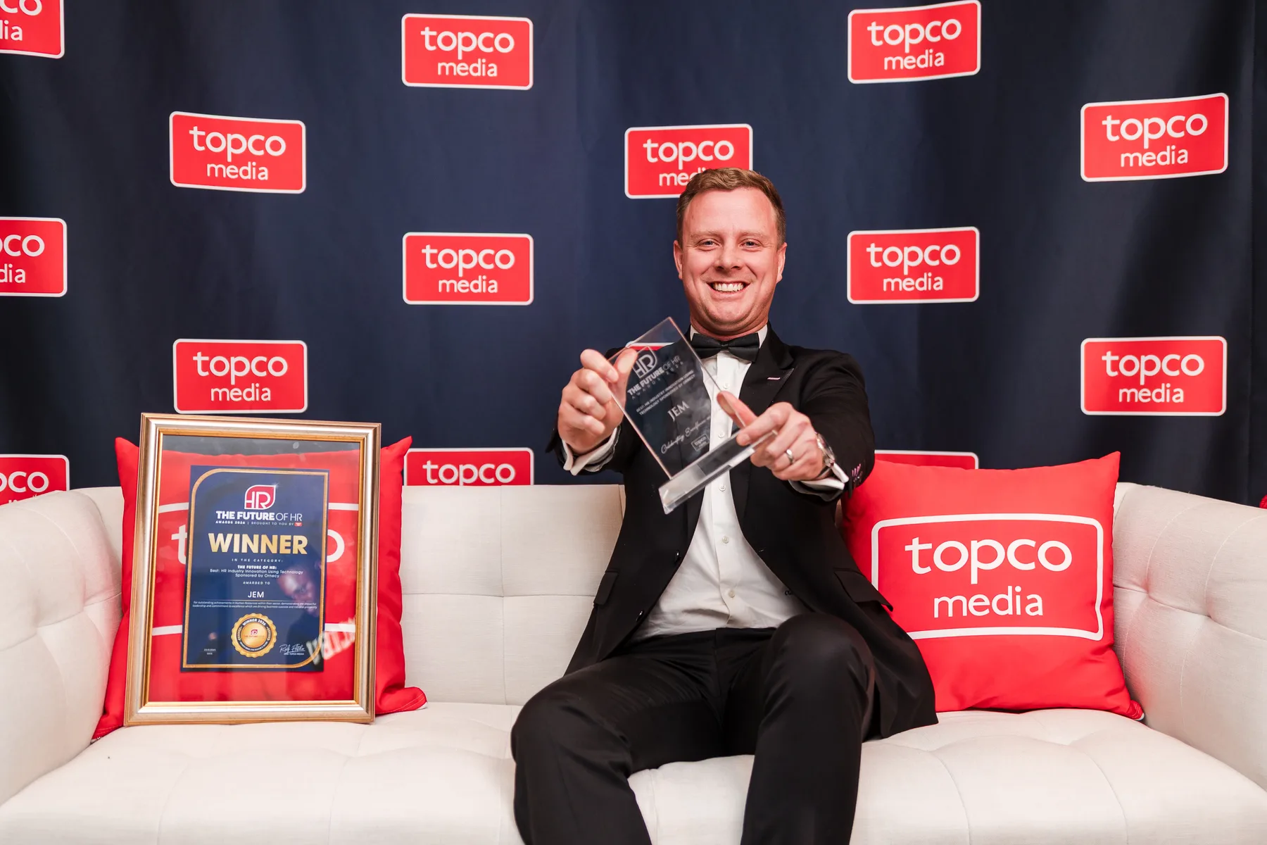 Christopher Hellmann holding Jem’s trophy beside its winner certificate at the Future of HR Awards 2026