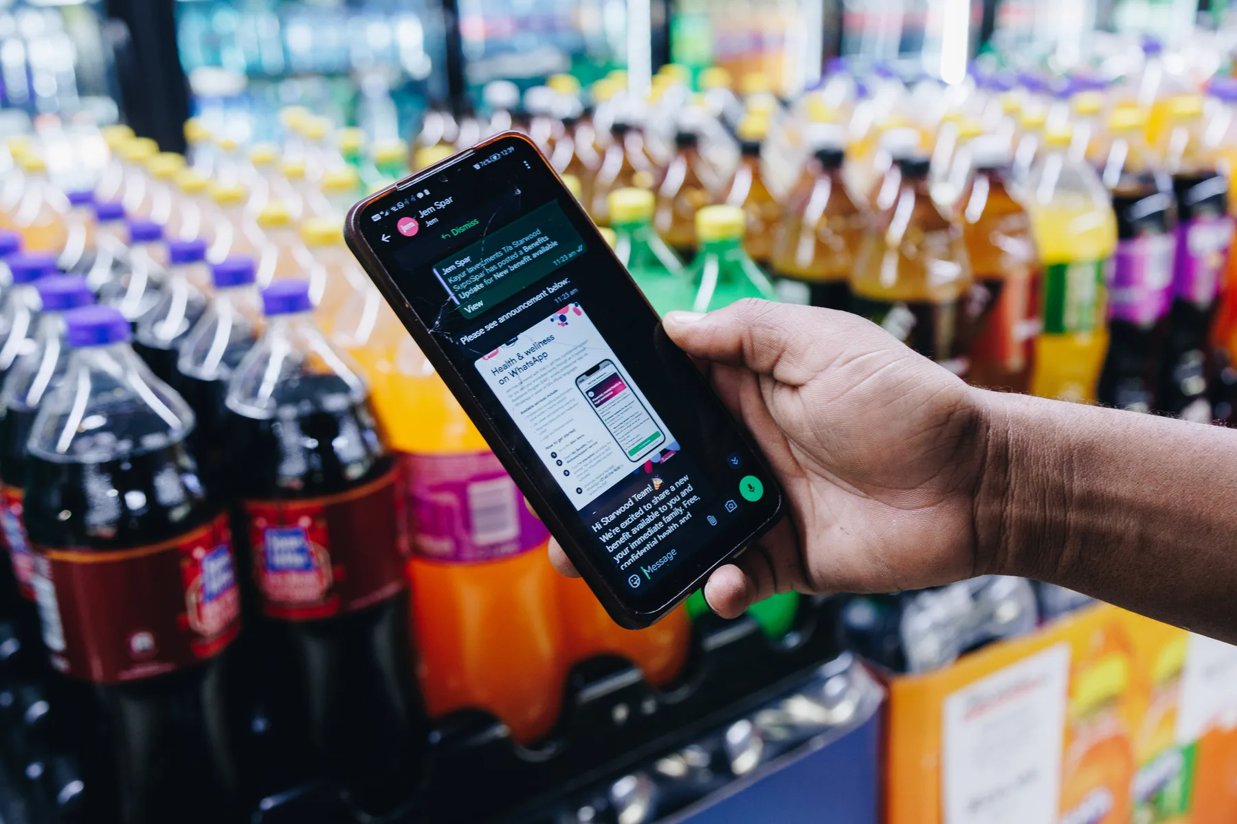 A phone displaying a payslip in Jem’s WhatsApp chat in a supermarket
