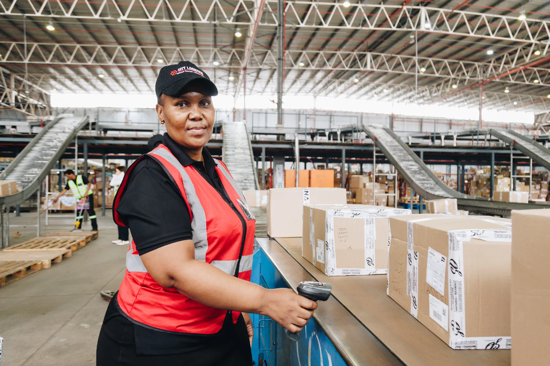 Warehouse employee scanning parcels on a conveyor belt
