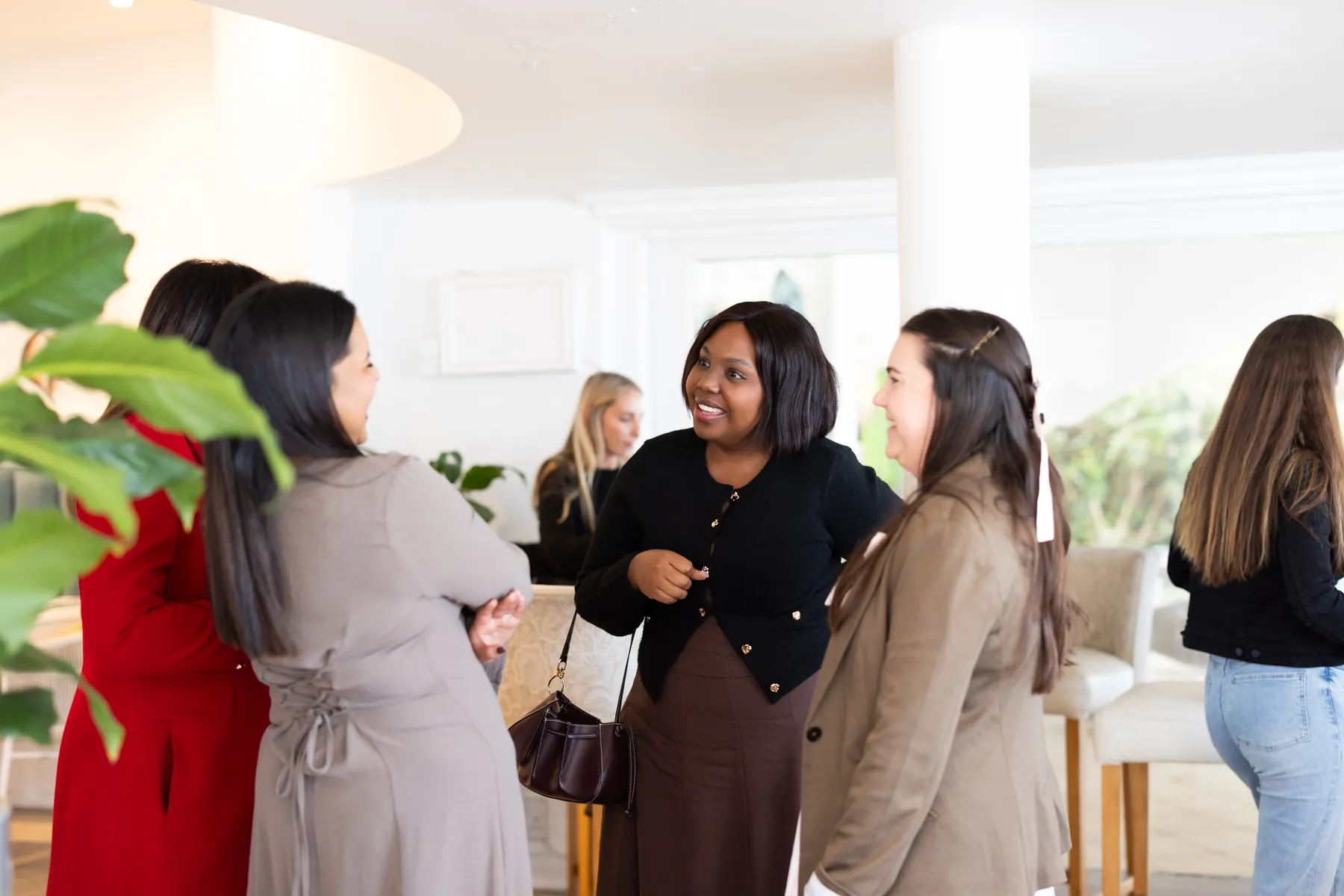 Guests standing in conversation in the hotel lounge before the lunch.