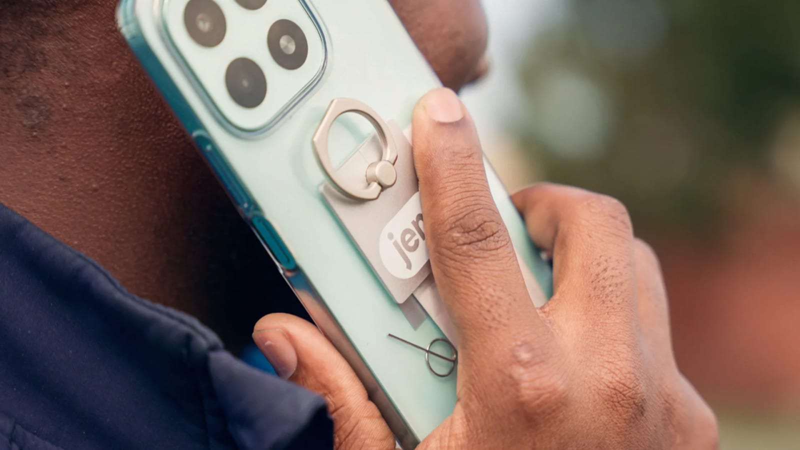 A pair of hands holding a phone in a mint green case